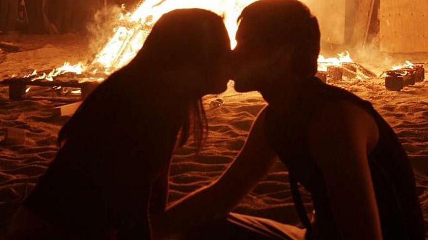 Una pareja se besa en una playa coruñesa. / fran martínez