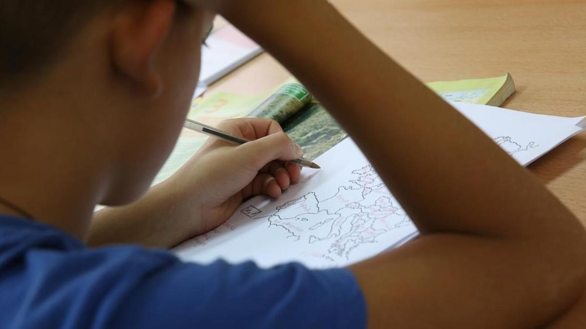 Un niño estudia Geografía en su casa.