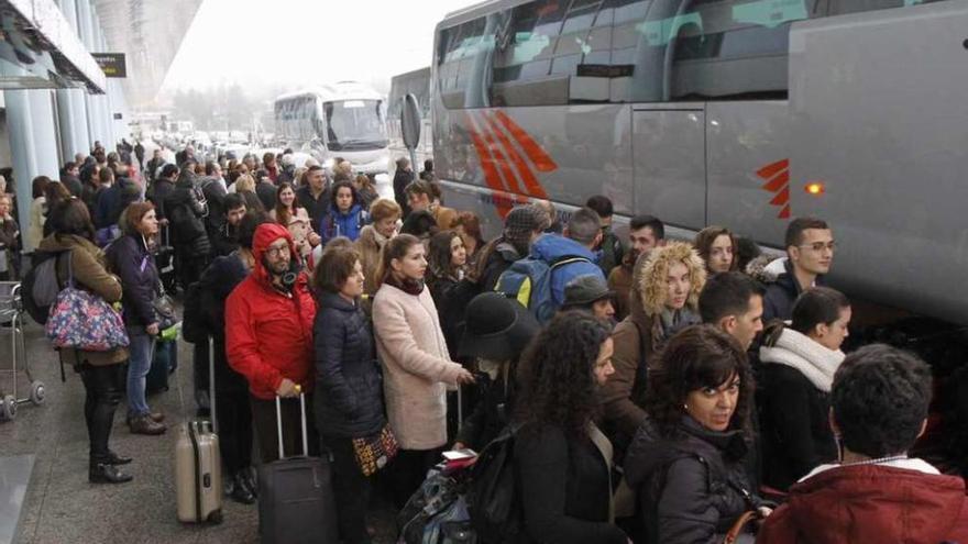 Viajeros afectados por los desvíos de ayer y que fueron llevados en bus al aeropuerto de Lavacolla. // Lores