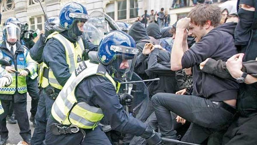 Los policías golpean a los manifestantes concentrados ante el Banco de Inglaterra.