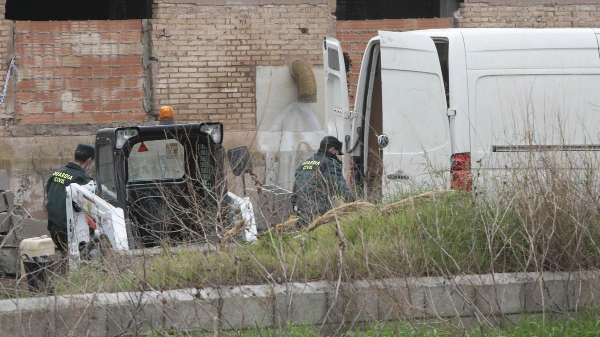 Dos Guardias Civiles con una máquina para empezar los trabajos de demolición de la fábrica afectada por el incendio