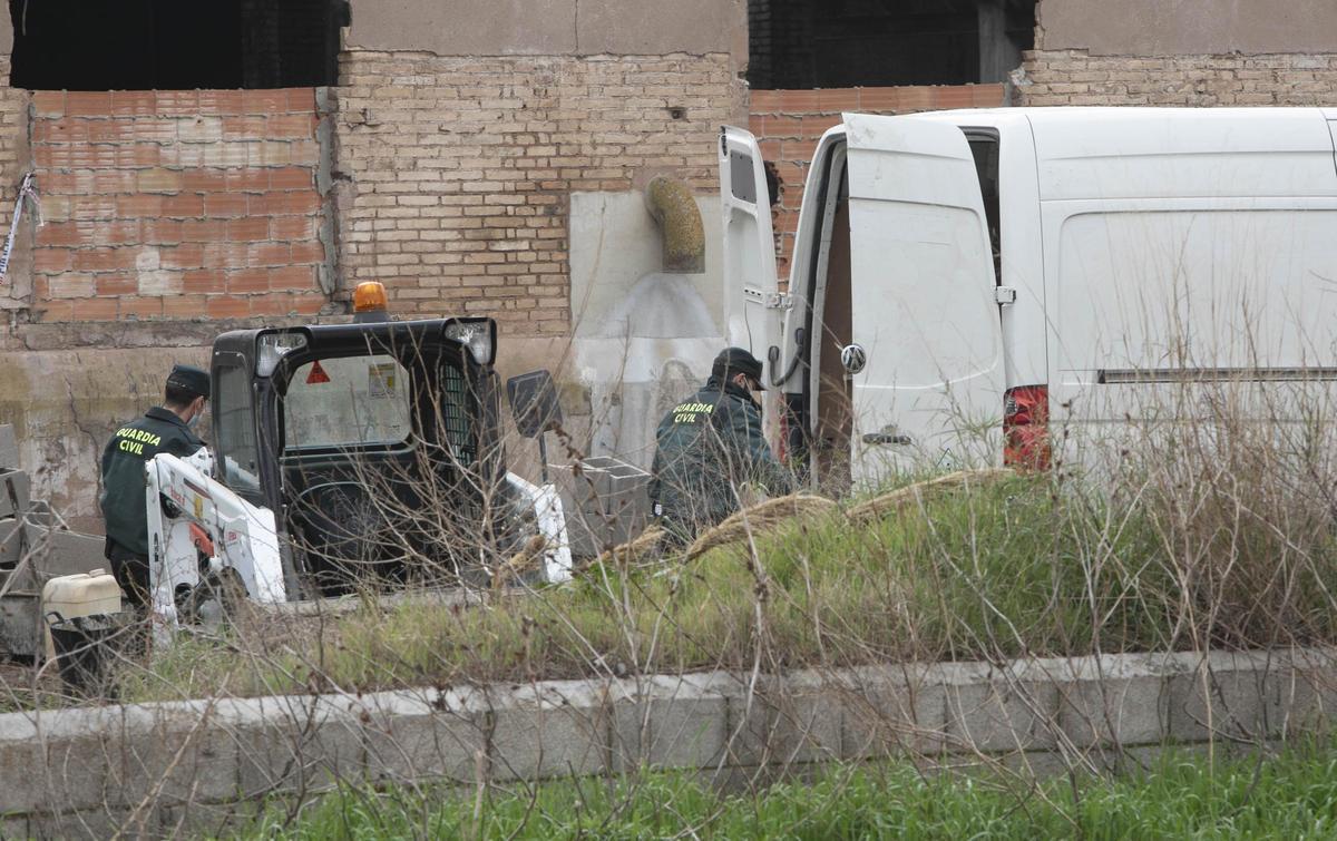 Dos Guardias Civiles con una máquina para empezar los trabajos de demolición de la fábrica afectada por el incendio
