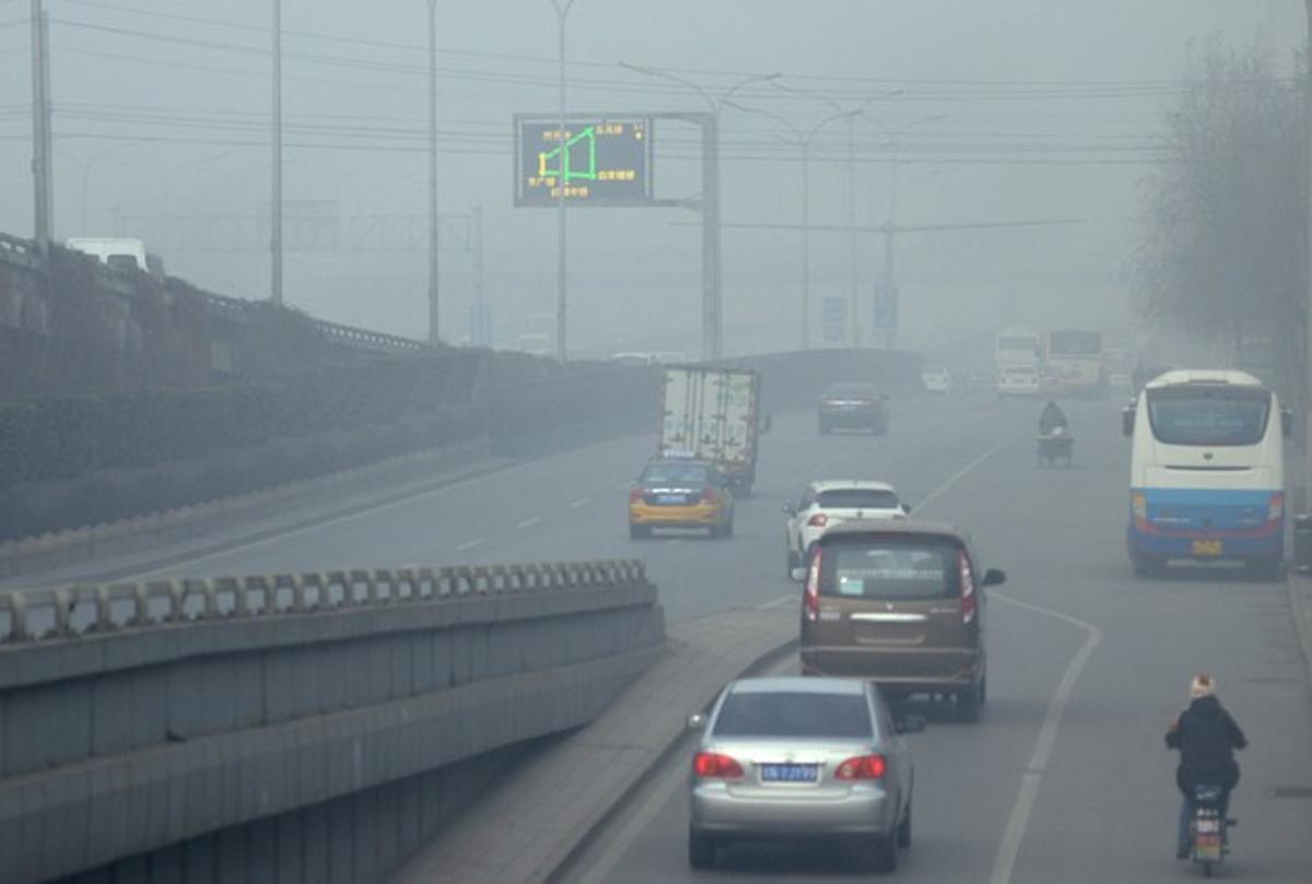 Diversos vehicles circulen per una carretera plena de pol·lució, aquest divendres, a Pequín.