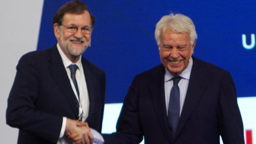 Rajoy y González se saludan antes de la charla.