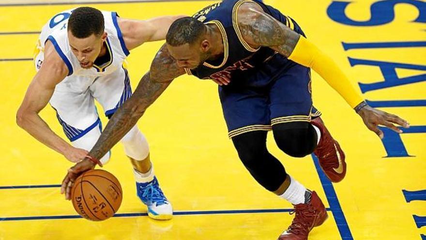 Stephen Curry (esquerra) va guanyar el primer combat a LeBron James