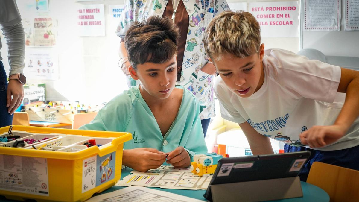 Nacho López Tejeda e Iván durante el taller de robótica en el Hospital Materno Infantil de Badajoz.
