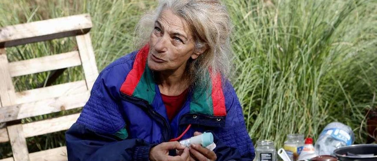 María Luisa Mora, sentada junto al lugar donde cocina, al lado de las vías del tren.