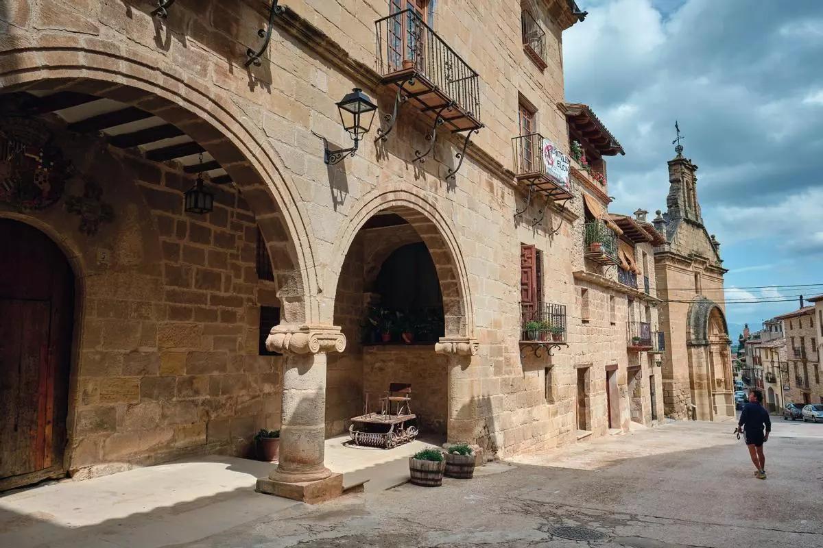 Un turista pasea junto a la Casa de la Encomienda, un edificio renacentista del pueblo de La Fresneda. Al fondo, la capilla del Pilar