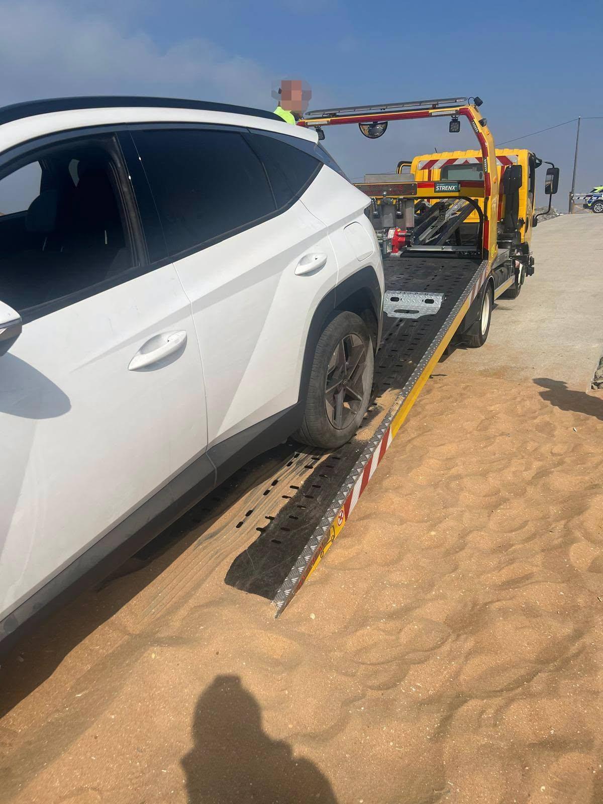 El coche aparcado en la arena de la playa.