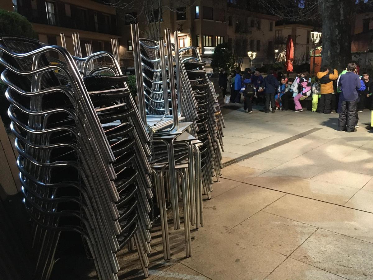 Cadires apilades de bars tancats