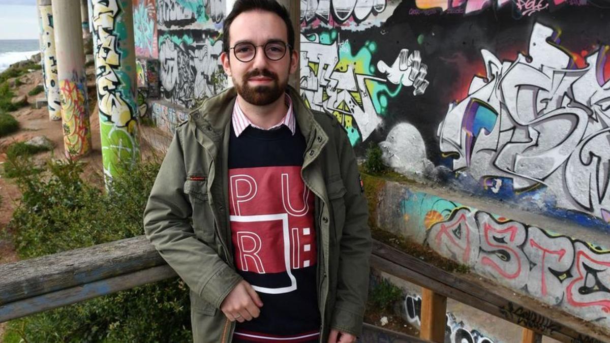 El microbiólogo Dimas Martínez, junto a los grafitis del Paseo Marítimo.