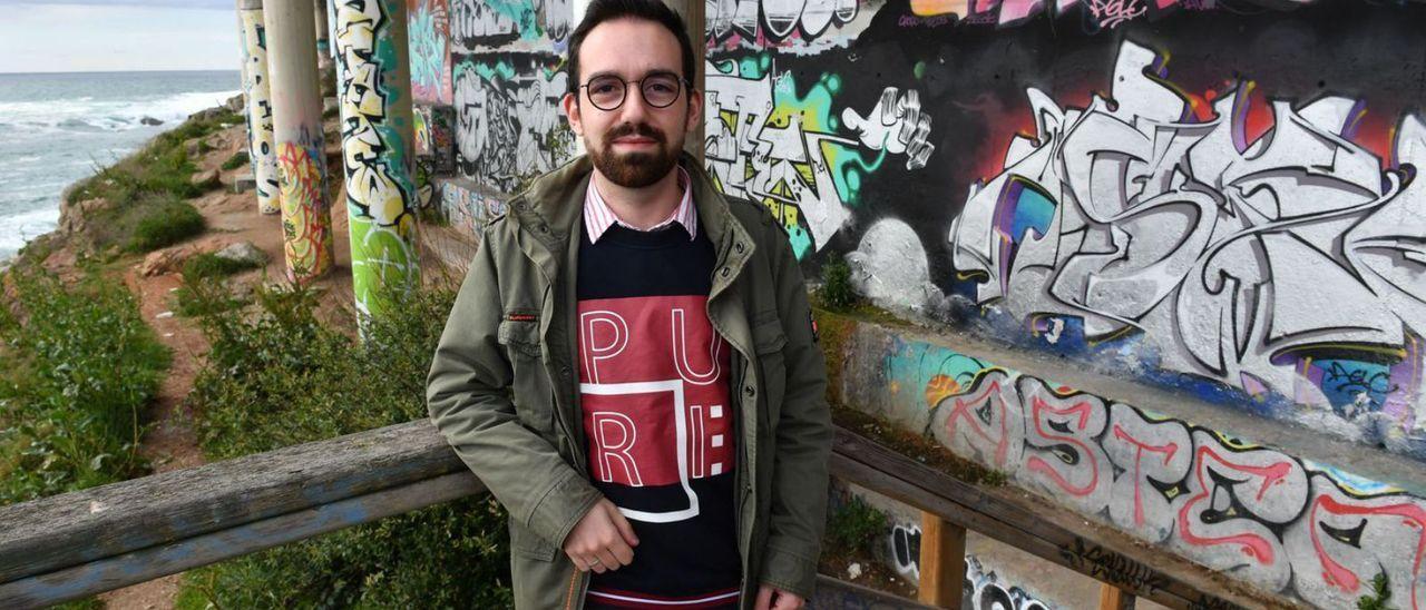 El microbiólogo Dimas Martínez, junto a los grafitis del Paseo Marítimo.