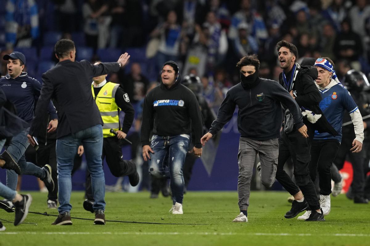 Ultras del RCD Espanyol invaden el césped de Cornellà tras el final del partido contra el FC Barcelona.