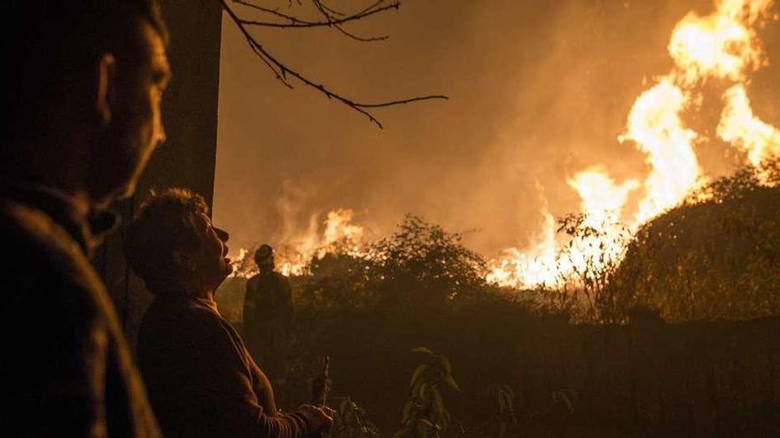 Vecinos observan la altitud que alcanzaban las llamas en el incendio de Carballeda de Avia. // Brais Lorenzo