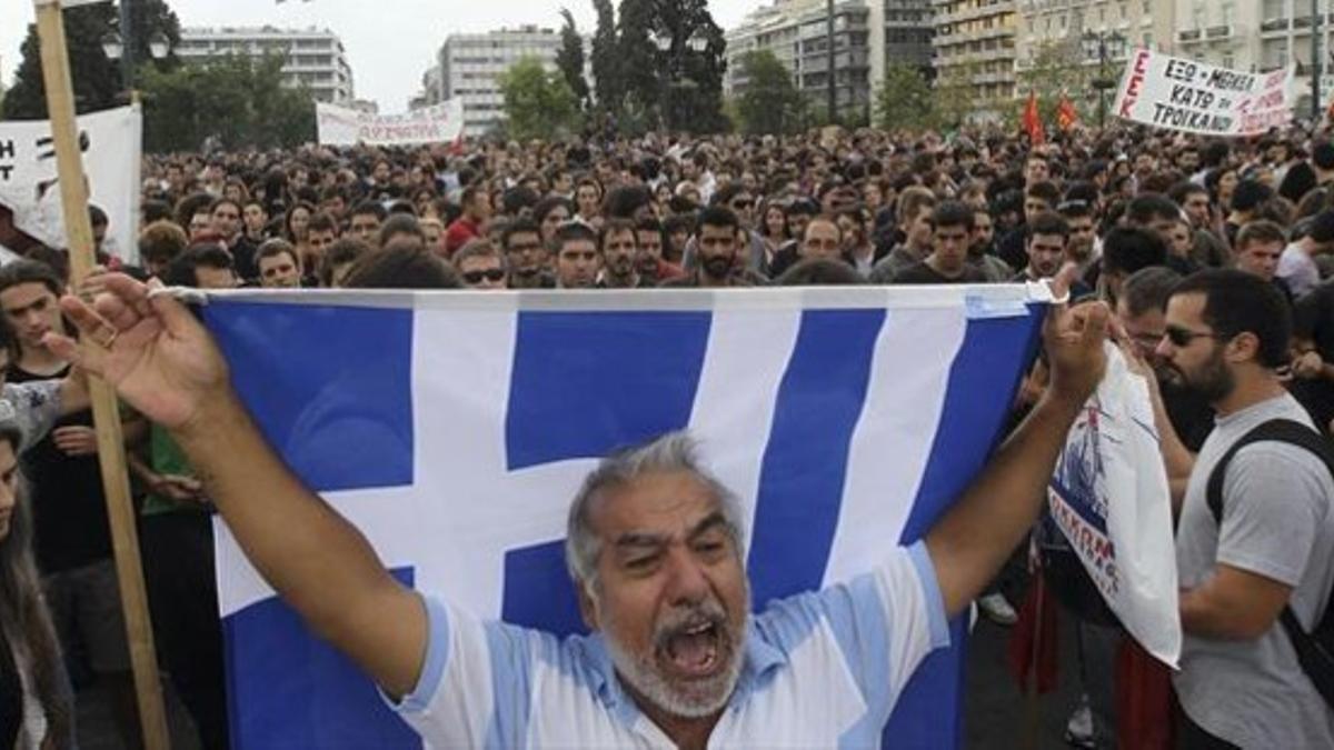 Un hombre sostiene una bandera de Grecia en una concentración contra los ajustes económicos, el 9 de octubre en Atenas.
