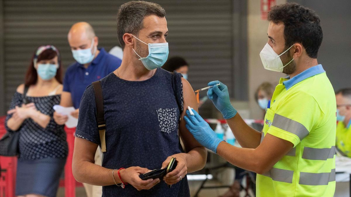 Un enfermero pone la vacuna Pfizer a un hombre en el Estadio Nueva Condomina de Murcia.
