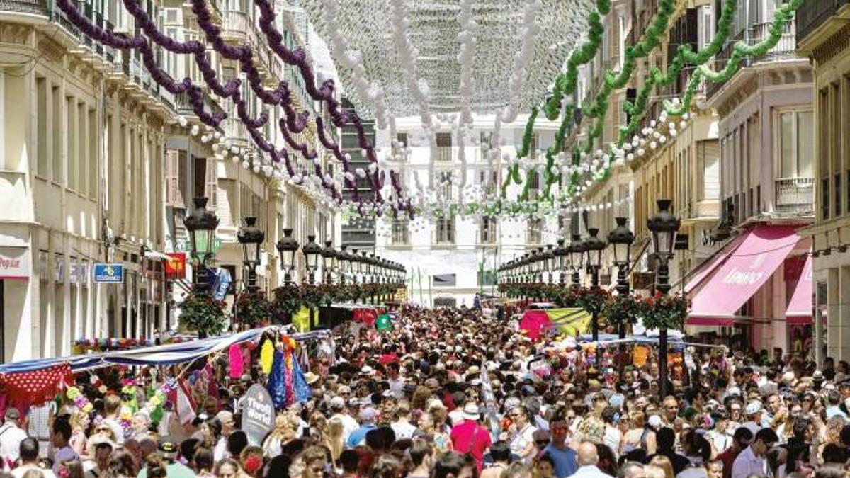 Cientos de personas disfrutan, en la popular calle Larios, de la Feria de Málaga