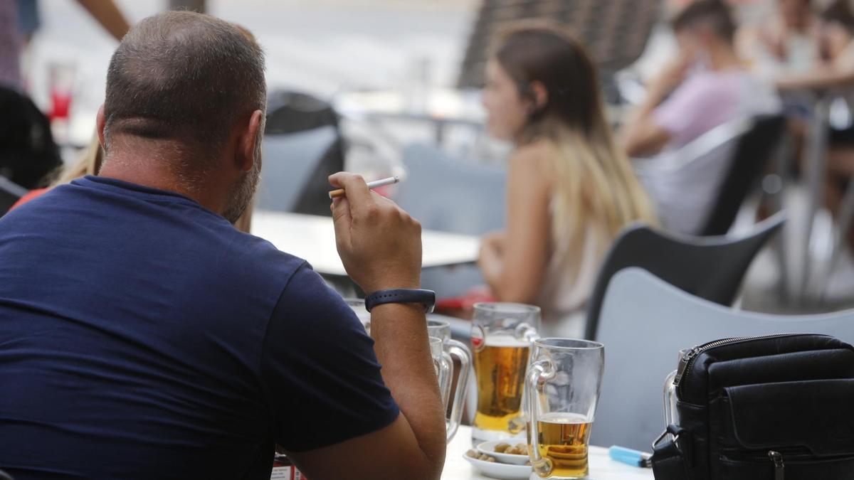 Un hombre fuma en una terraza