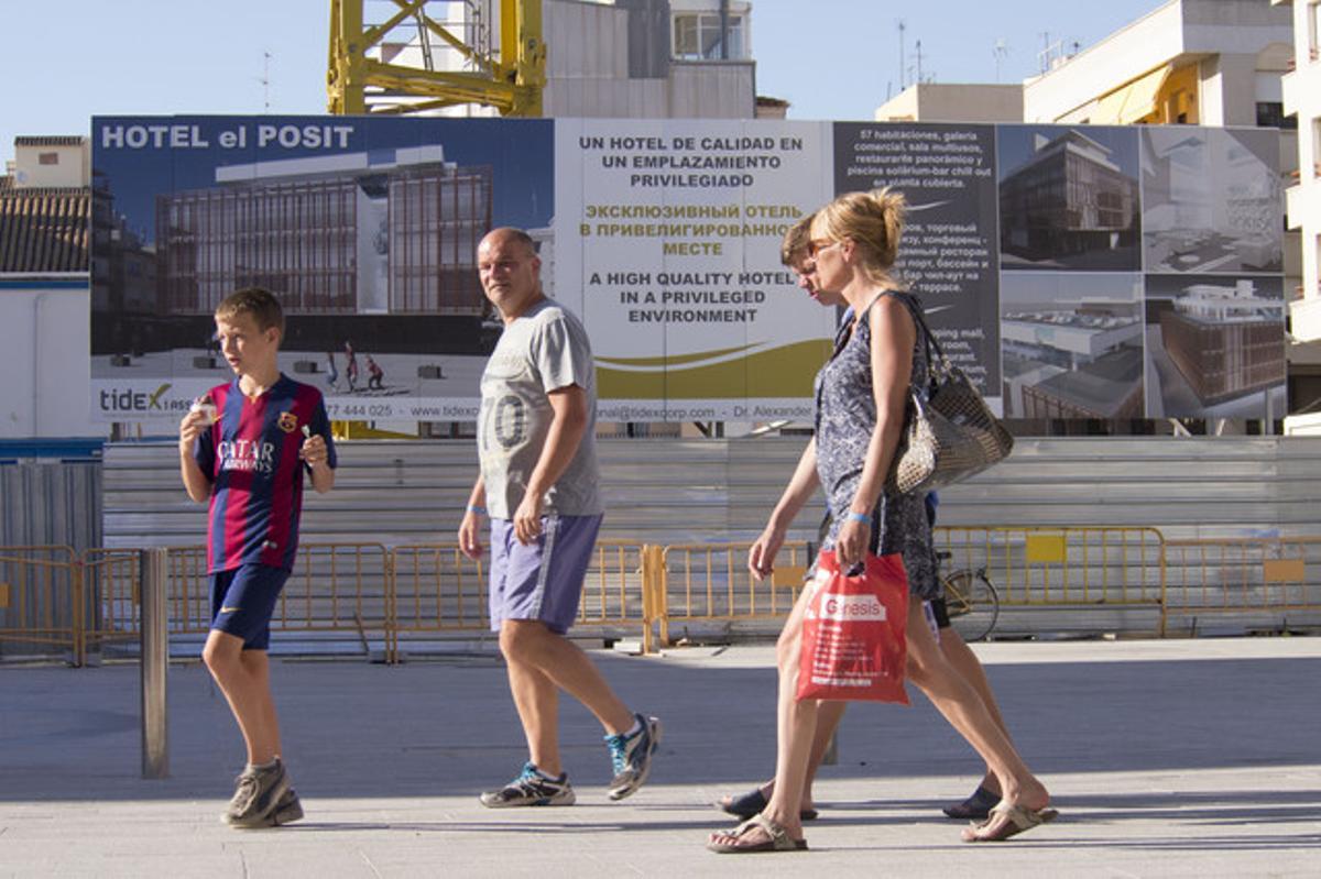 Turistes russos passen davant d’un hotel en construcció a Cambrils. Turistes russos passen davant d’un hotel en construcció a Cambrils.