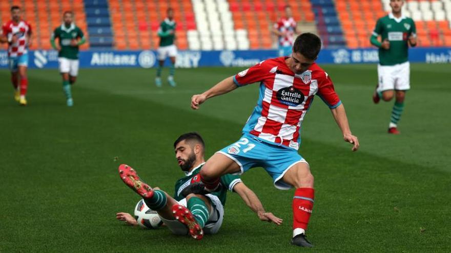 Andriu, del Coruxo, intenta arrebatarle el balón al lucense Iago Novo durante el partido de ayer en Lugo. // EL PROGRESO