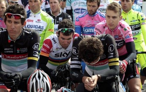 Team Sky rider Cavendish and the overall leader BMC Team rider Phinney observe a minute of silence with the pack of riders in memory of Belgian rider Weylandt who died last year, before the start of the190-km third stage of the Giro d'Italia in Horse