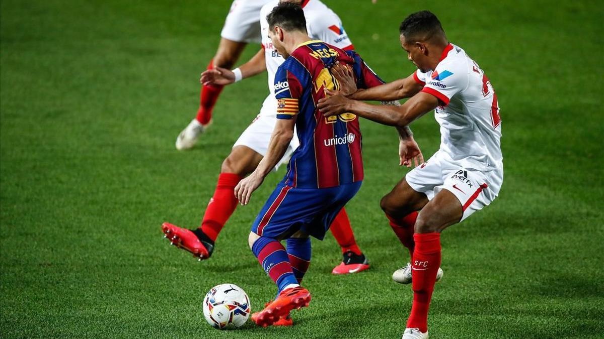 Leo Messi lucha el balón ante dos jugadores del Sevilla