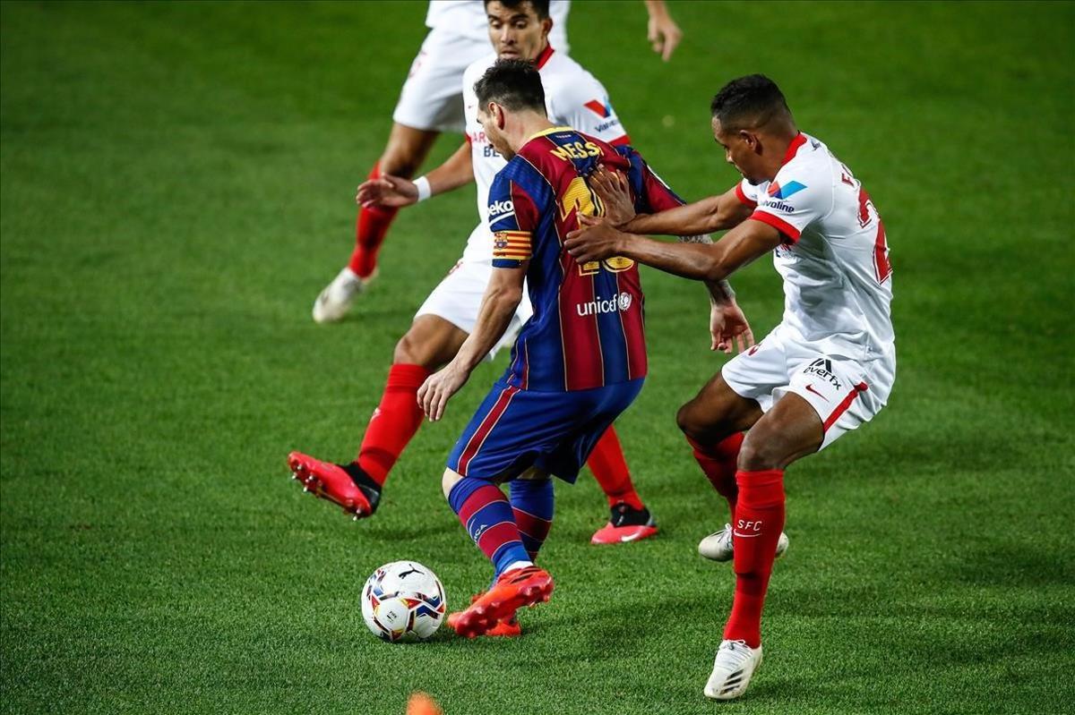 Leo Messi lucha el balón ante dos jugadores del Sevilla
