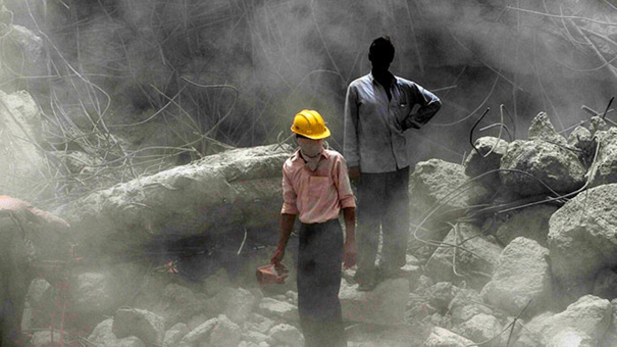La cara d’un membre d’un grup de rescat indi s’amaga sota l’ombra. Queden poques esperances de trobar amb vida un grup de treballadors que van quedar atrapats arran del col·lapse d’una construcció a Jhansi.