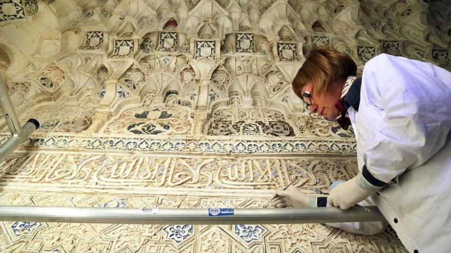 Una restauradora trabaja en la decoración de yeso que conforma la cúpula del templete del Patio.