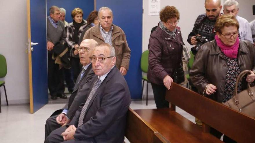 Dos de los acusados, en el banquillo, mientras acceden a la sala antiguos trabajadores de GEA. // M.G.B.