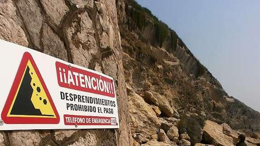 Un visitante observa el argayo de la playa de El Sablón.