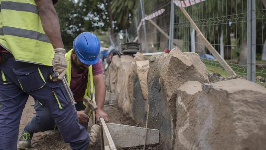 Dos obreros trabajan en la reforma de un parque público.