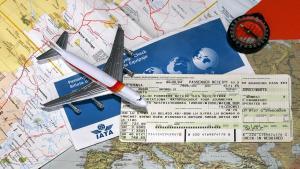 Un billete de avión junto a un mapa y un avión de juguete.