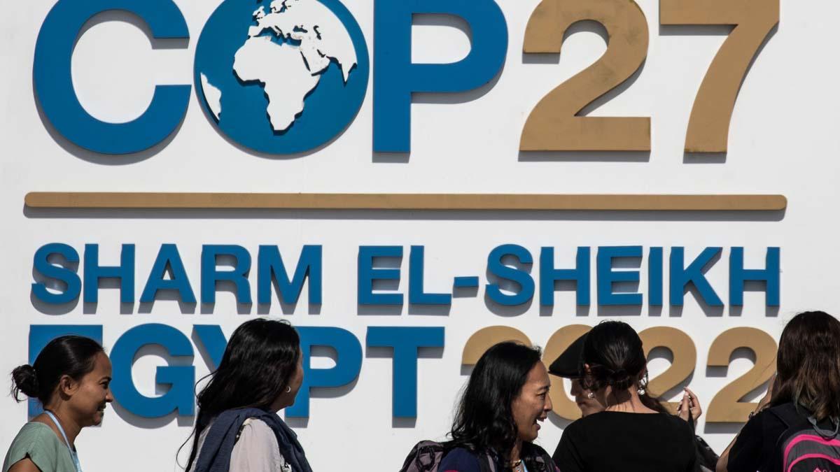 Conferencia de Cambio Climático COP27,Los asistentes se paran frente al logotipo de la Conferencia de las Naciones Unidas sobre el Cambio Climático.