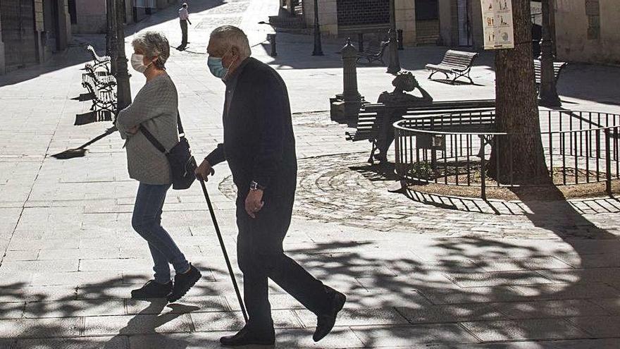 Persones grans protegides amb mascareta passejant per la Plana de l&#039;Om de Manresa