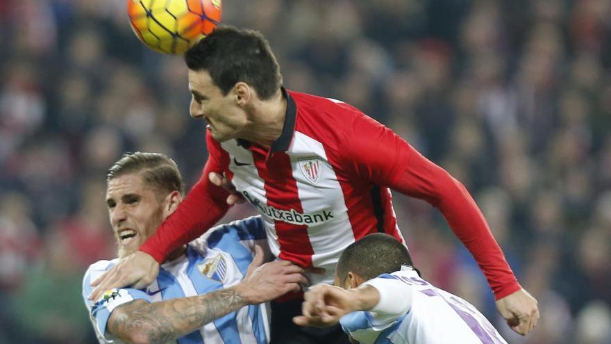 Aduriz disputa un balón con dos jugadores del Málaga.