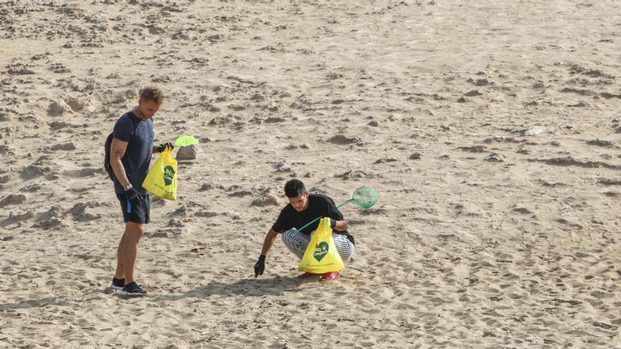 Dos voluntarios participan en una limpieza de playas en Ibiza, en una imagen de archivo.