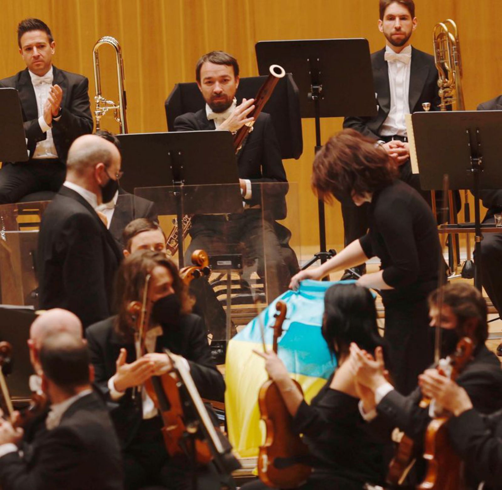 Yuri Pisarevskiy y Marina Gurdzhiya, compañeros rusos de la chelista ucraniana, despliegan la bandera de Ucrania sobre su silla vacía en el concierto del sábado en Oviedo. 