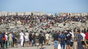 Miembros de la Cruz Roja reparten comida a los inmigrantes en una playa, a 21 de agosto de 2026, en Ceuta (España).