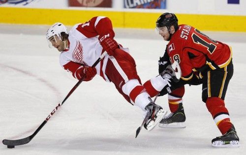 Matt Stajan (Calgary Flames) hace volar a Patrick Eaves (Detroit Red Wings) provocando un penalti