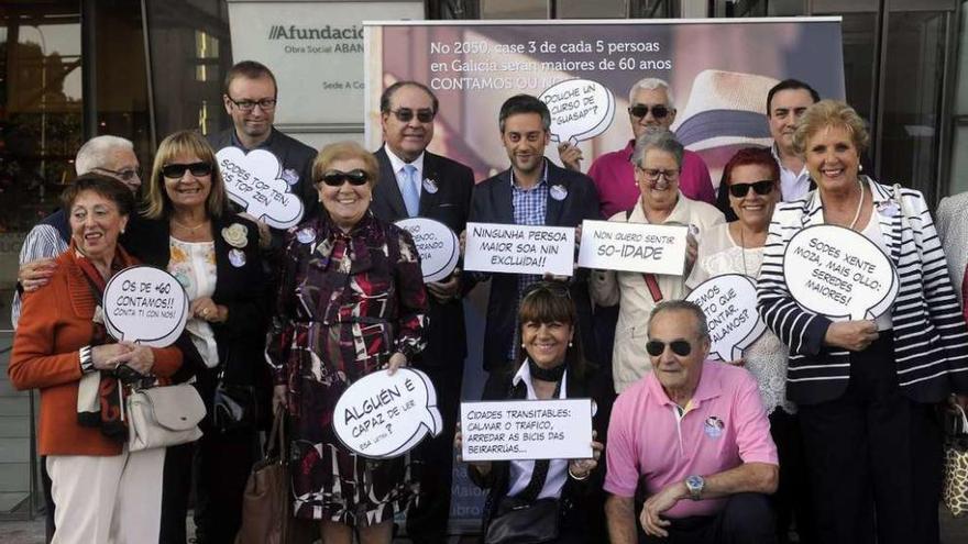 El presidente de Afundación, Miguel Ángel Escotet, y el alcalde de A Coruña, Xulio Ferreiro, con un grupo de mayores, ayer, en el &#039;photocall&#039;, delante de la sede de A Coruña.