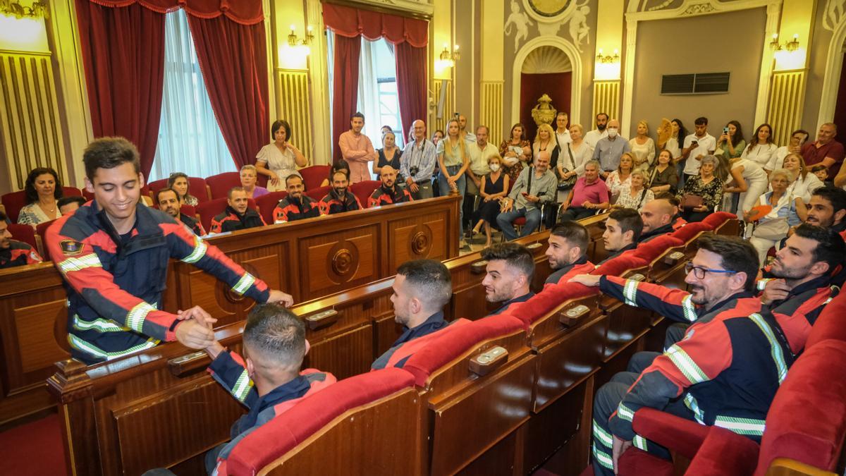 Los bomberos que tomaron posesión con los familiares al fondo.