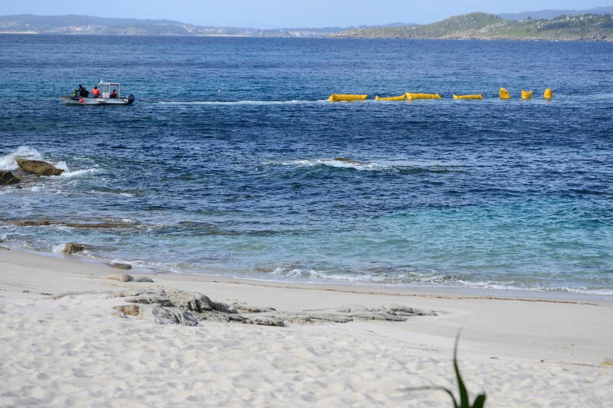 Buzos trabajando ayer en la instalación del emisario para captar agua del mar en la playa de Rabáns.