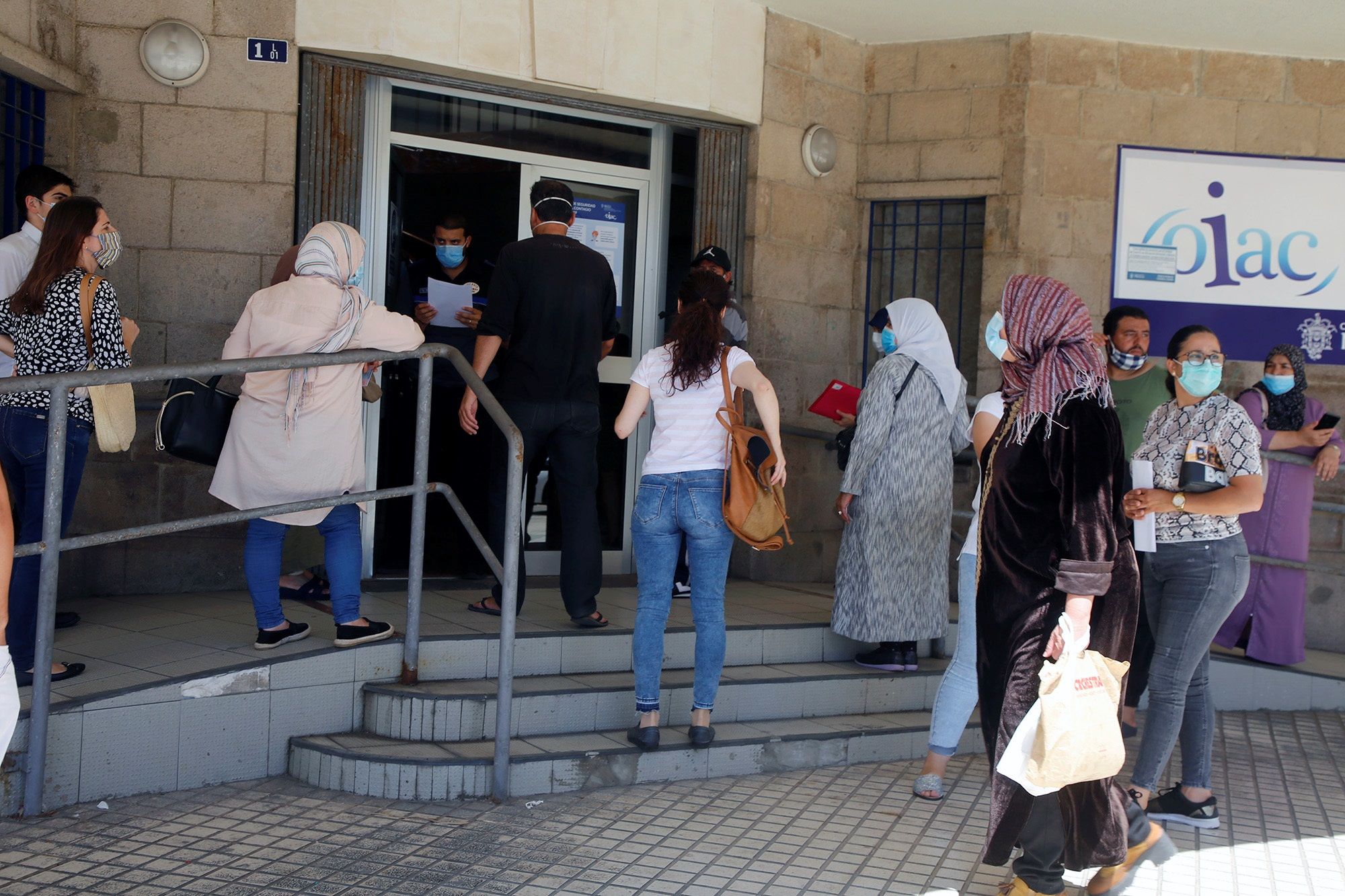 Varias personas esperan su turno para solicitar los documentos con los que pedir el Ingreso Mínimo Vital (IMV), en Melilla, en una fotografía de archivo.