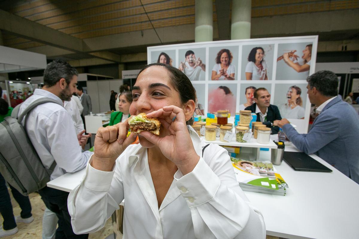 Una joven come una hamburguesa de origen alternativo, de polvo de insecto, durante la feria Alimentaria de 2024.