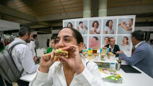 Una joven come una hamburguesa de origen alternativo, de polvo de insecto, durante la feria Alimentaria de 2024.