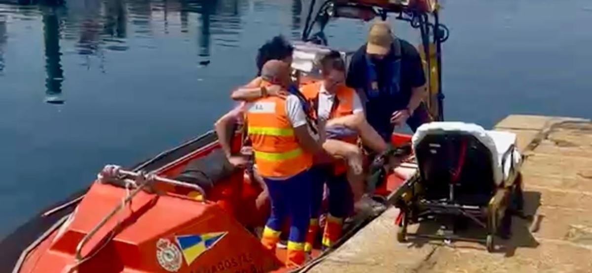 Traslado de la mujer en el muelle de Bueu a la ambulancia.