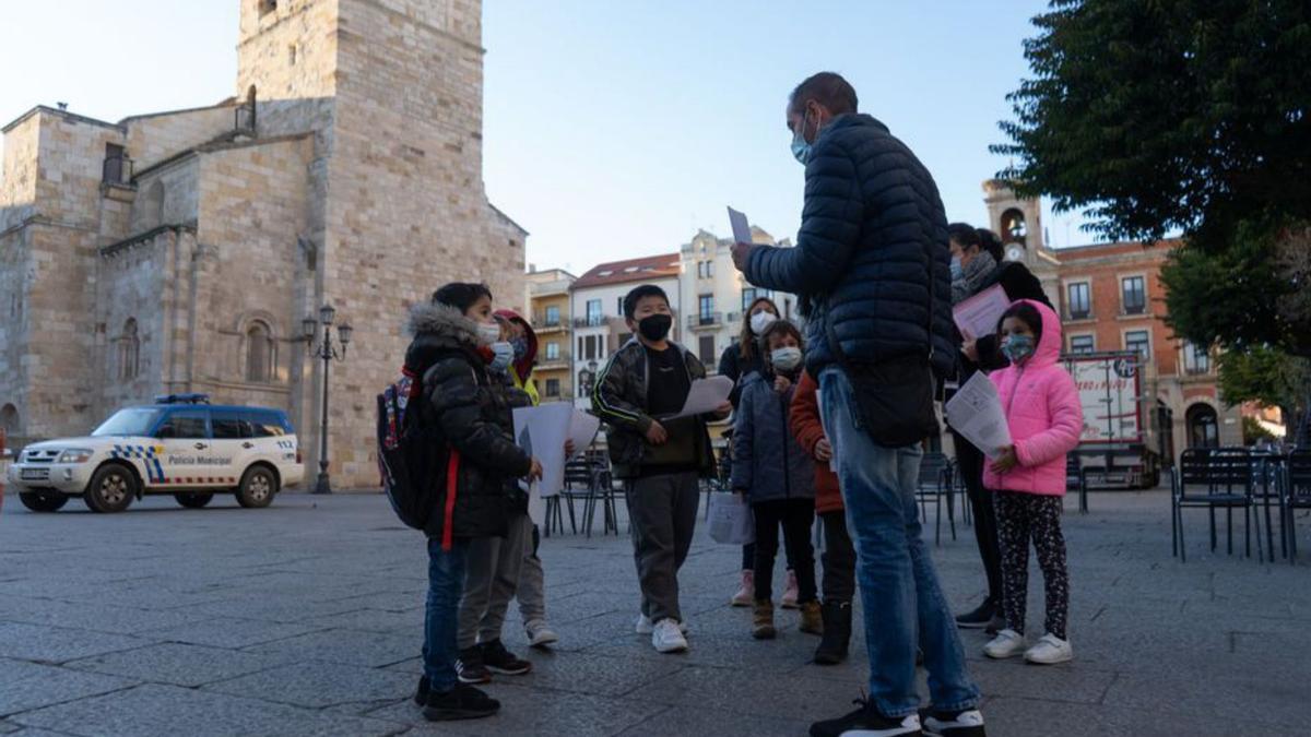 Alberto Alonso enseña a los niños una de las cartulinas. | J. L. Fernández