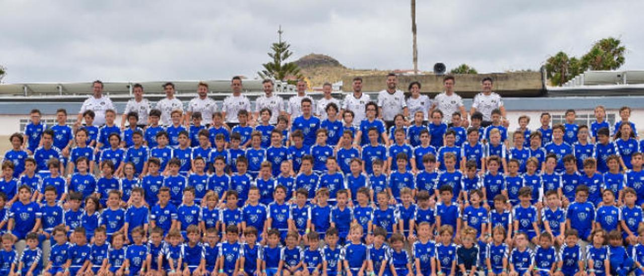 Foto de familia con los asistentes al campus de la Academy Trainning Gran Canaria con un grupo de monitores en la grada que da a la pista de atletismo y campo de fútbol del recinto claretiano.