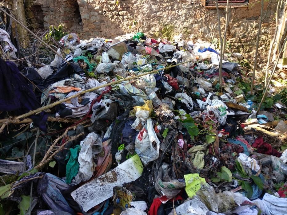 Muntanyes de peces de roba s''acumulen en una finca abandonada de Domeny